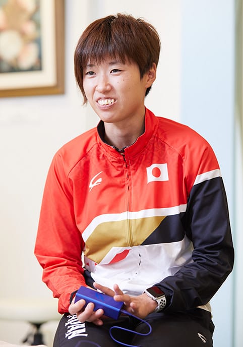 RUCOE RUNを手にインタビューに答える、「高松佑圭」選手